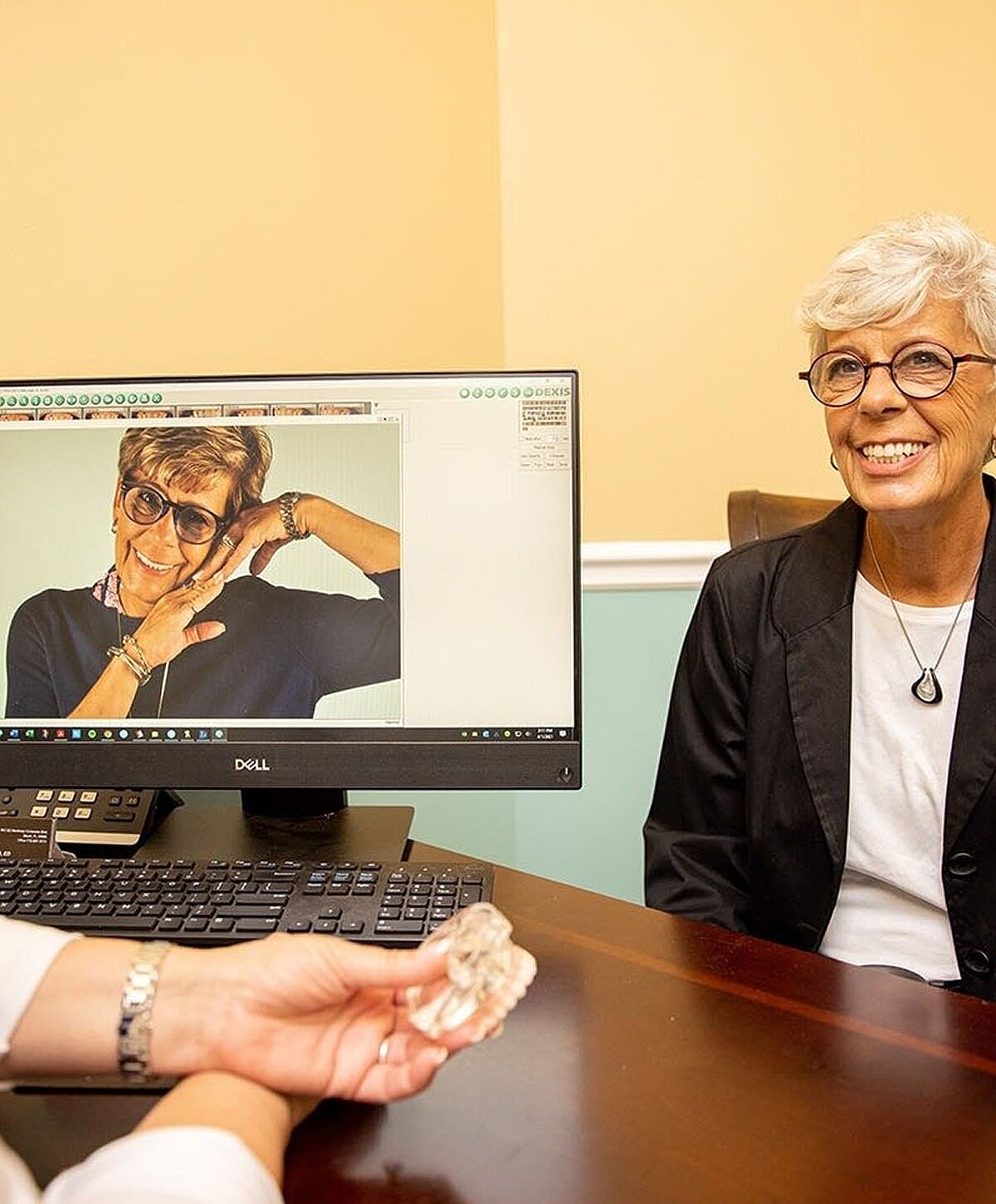 Woman smiling in consultation with digital display.