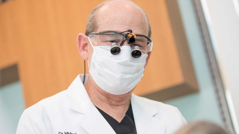 Dr. Michael Sohl wearing a surgical mask and special eyewear for dental implant surgery.